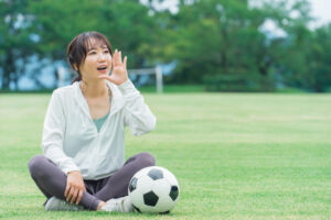 スポーツウェアでサッカーを応援するアジア人女性