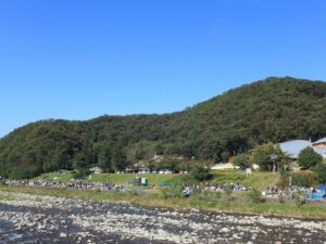 河原で芋煮を楽しむ人々